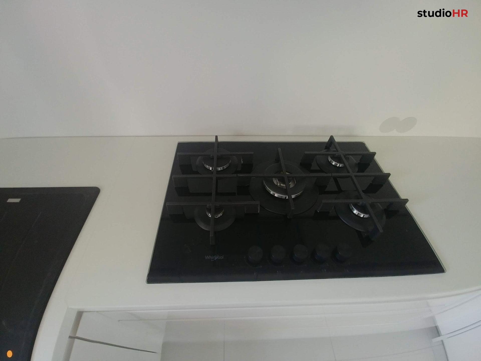 Crna plinska ploča za kuhanje na svijetloj radnoj ploči u bijeloj DanKuchen Granada kuhinji